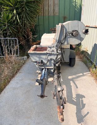 une machine qui se trouve sur le trottoir, à côté d'un immeuble