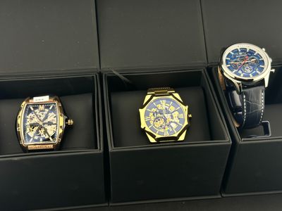 trois montres se trouvent dans une boîte noire posée sur une surface noire