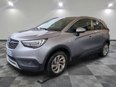 une voiture grise est garée sur le sol à carreaux d'un garage