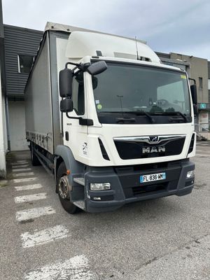 un camion blanc garé devant un bâtiment