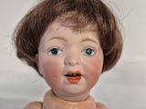 a small doll that is sitting on a white surface