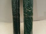 two rolls of green plastic wrap sitting on top of a white surface