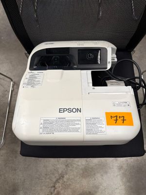 une imprimante blanche posée sur une chaise noire