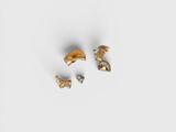 une paire de boucles d'oreilles en or et en argent posées sur une surface blanche