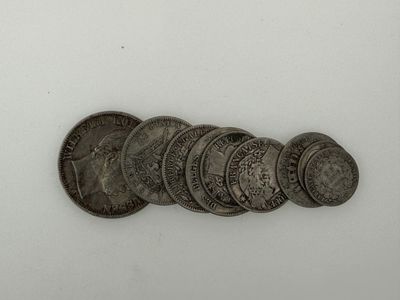 five silver coins are arranged in a row on a white surface