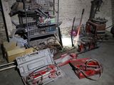 un tas d'outils dans une pièce où se trouve une cage accrochée au mur