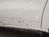 a white car with holes in the side of it