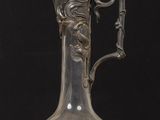 a glass vase with a bird on it on a table