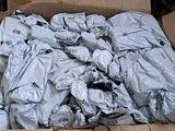a cardboard box full of clothes that is sitting on the ground