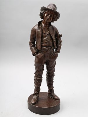 une statue en bronze représentant un homme portant un chapeau et une veste