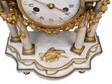 a white and gold clock sitting on top of a table