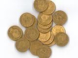 une pile de pièces d'or posée sur une surface blanche