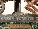 bronze statue of a horse and carriage with a man on it