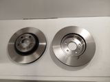 un gros plan de deux disques de frein sur une surface blanche