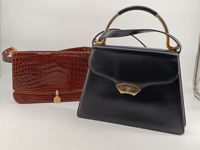 deux sacs à main noirs et marron posés l'un à côté de l'autre sur une surface blanche