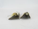 two pieces of metal are sitting on top of a white surface