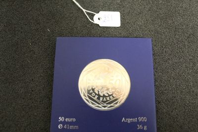 une pièce d'argent posée sur une boîte bleue