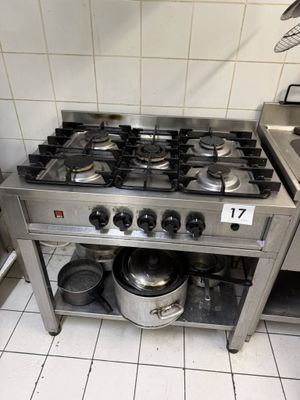 une cuisinière sur laquelle sont posées des casseroles et des poêles, dans une cuisine