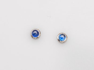 a pair of blue glass stud earrings on a white surface