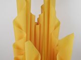 yellow paper flowers in a vase on a white table
