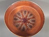 a brown bowl with a flower design on it