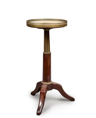a small wooden table with a gold top on a white background