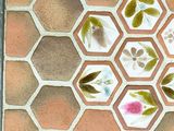 a picture of a tile with flowers and leaves on it
