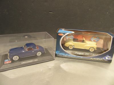 deux petites voitures qui se trouvent dans une boîte sur une table