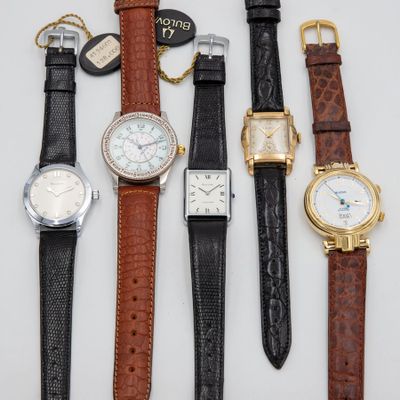 several different types of watches are lined up on a white surface