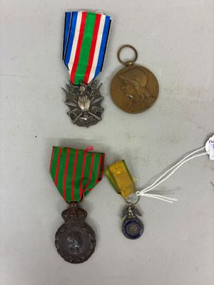 trois médailles et une médaille sur une surface blanche