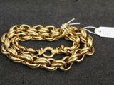 gros plan d'un bracelet en chaîne en or sur une surface noire