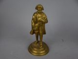 brass figurine of a man with a hat and coat on a pedestal