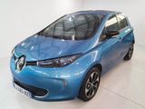 La voiture bleue est garée dans une pièce blanche au sol blanc.
