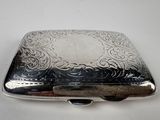 a silver box with a design on it on a white surface