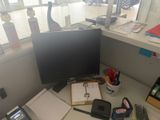 a desk with a computer monitor and other office supplies