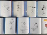 several open books with drawings of people on them sitting on a table