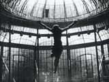 black and white photograph of a man on a cross suspended from the ceiling