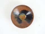 a brown bowl with a black and yellow design on it