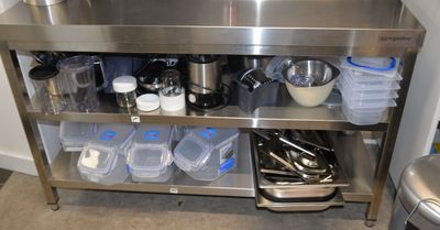 a stainless steel kitchen island with pots and pans on it