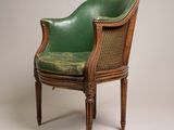 an old chair with a green leather seat on a white background