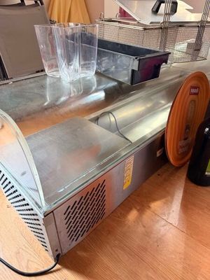 une machine posée par terre à côté d'une bouteille de vin