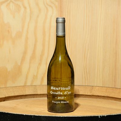 une bouteille de vin posée sur un tonneau