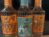 Trois bouteilles de rhum « The Hive » sont posées sur une table
