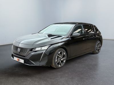 a black car is parked in a room with a white wall