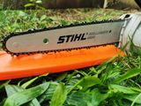 a close up of a chainsaw sitting on top of a green grass covered field