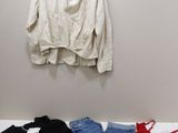 three shirts hanging on the wall next to a pair of jeans