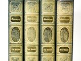three old books sitting on top of each other on a white surface