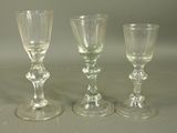 three wine glasses sitting next to each other on a table