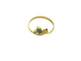 a close up of a gold ring with a green stone