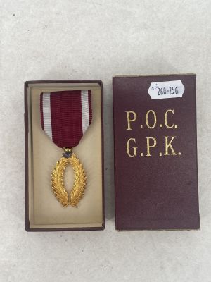 medal in a box on a white surface with a ribbon around it